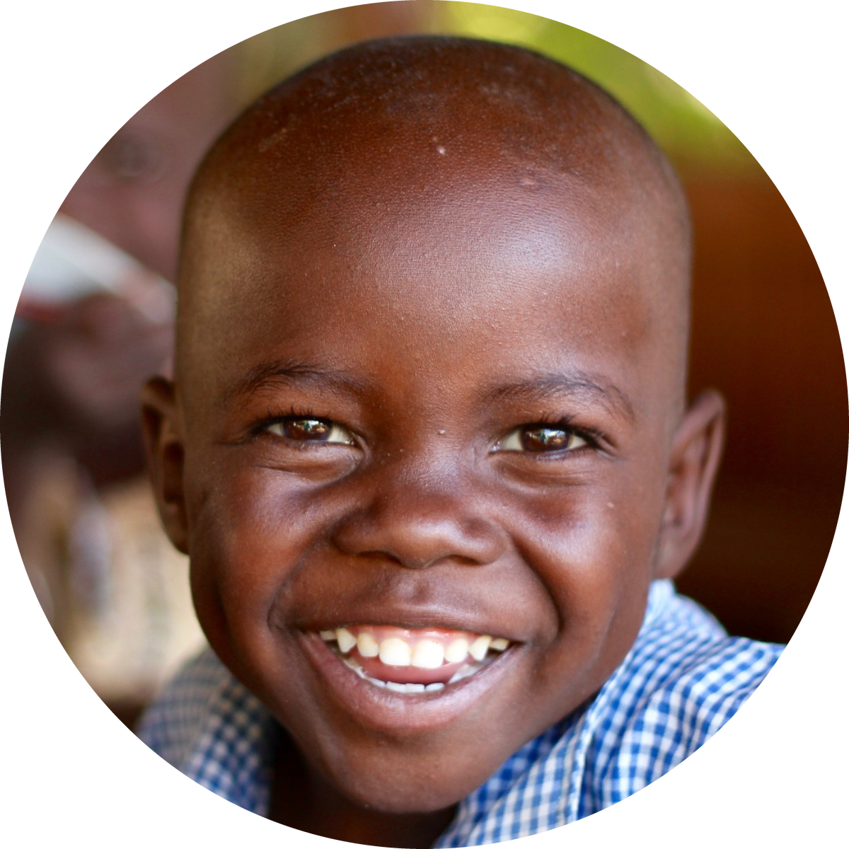 A smiling boy in a blue gingham school shirt.